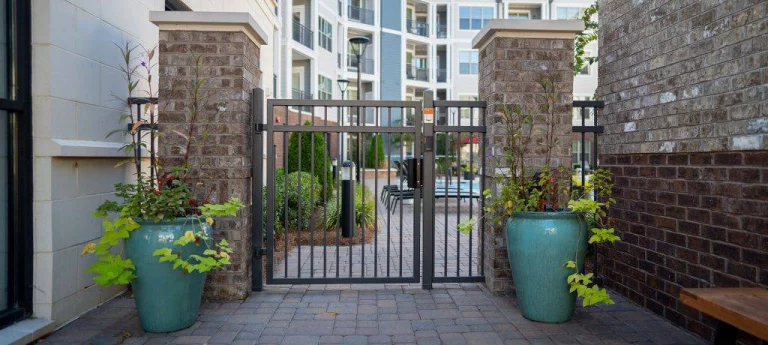 Metal apartments entrance gate with brick columns. aluminum fences.