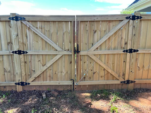 Sagging wooden gate with metal braces for support.